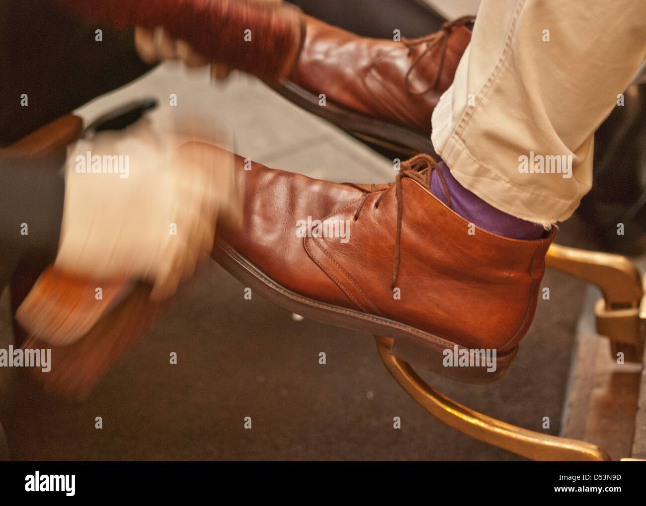 Cleaning brown boots. Polishing the leather quickly with a real horse