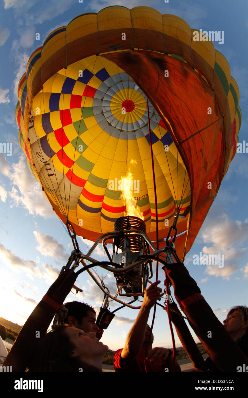 A crew member heats the air inside a hot air balloon envelope before a flight. Stock Photo