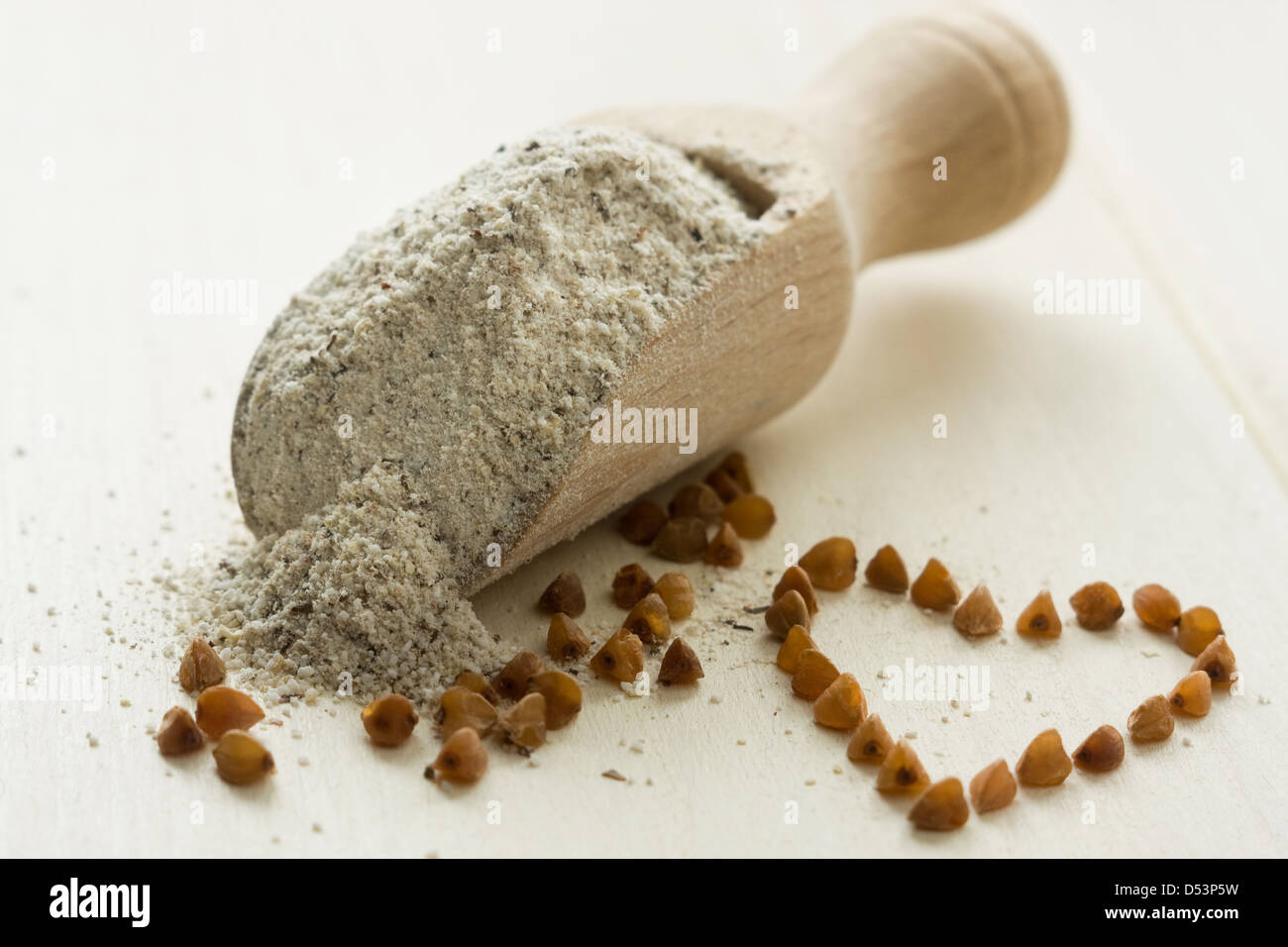 Buckwheat flour in wooden spoon. Buckwheat cereal and heart shape Stock Photo