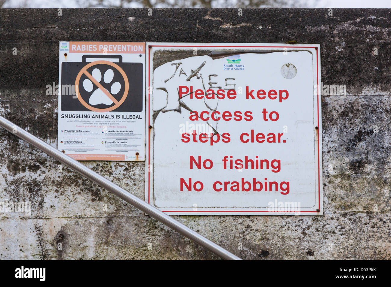 Warning notices on the harbour wall at Dartmouth. Stock Photo