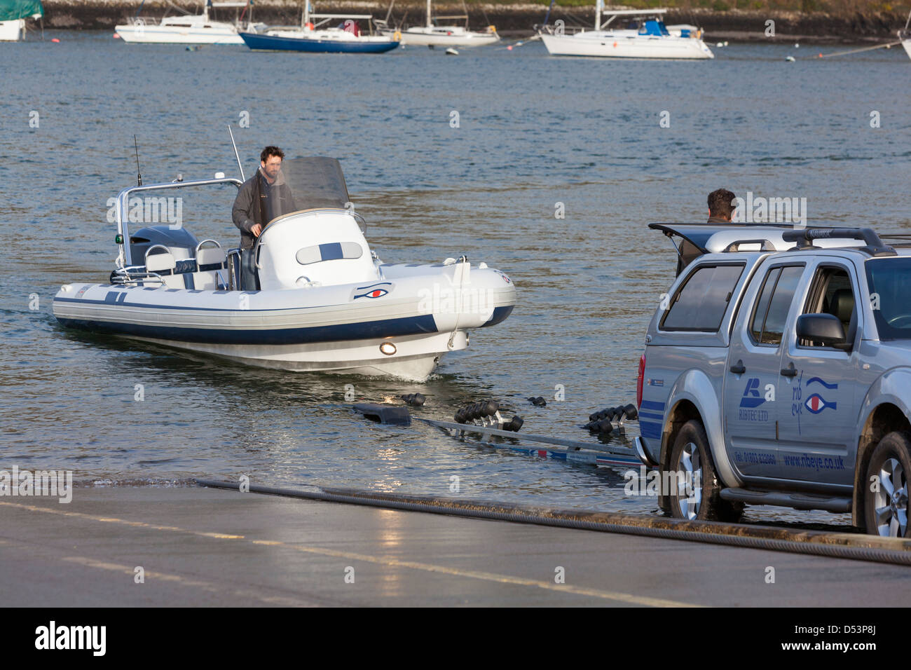 A RIB speedboat prepares to be winched aboard a trailer. Stock Photo