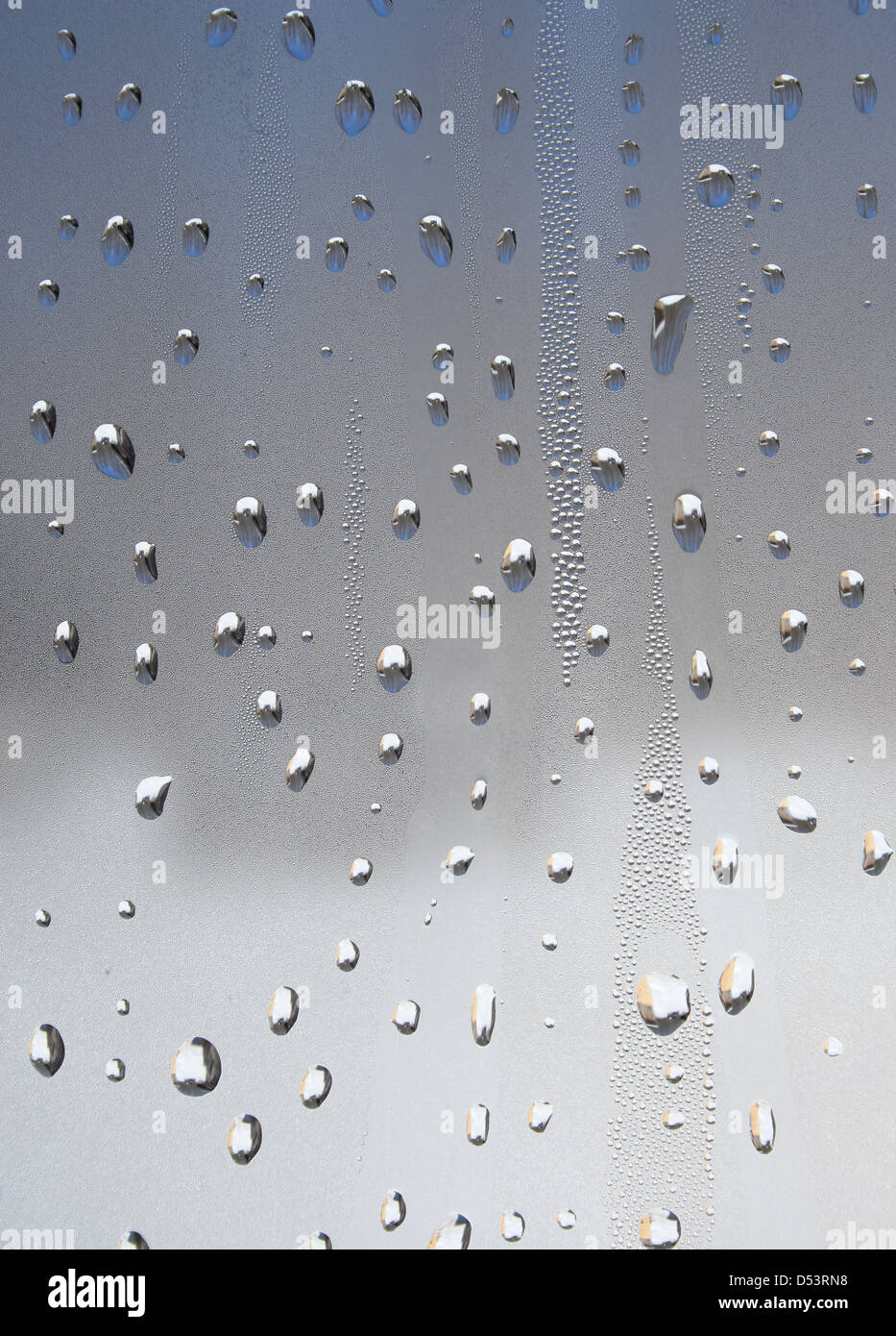 Water drops of metallic color on glass. Stock Photo