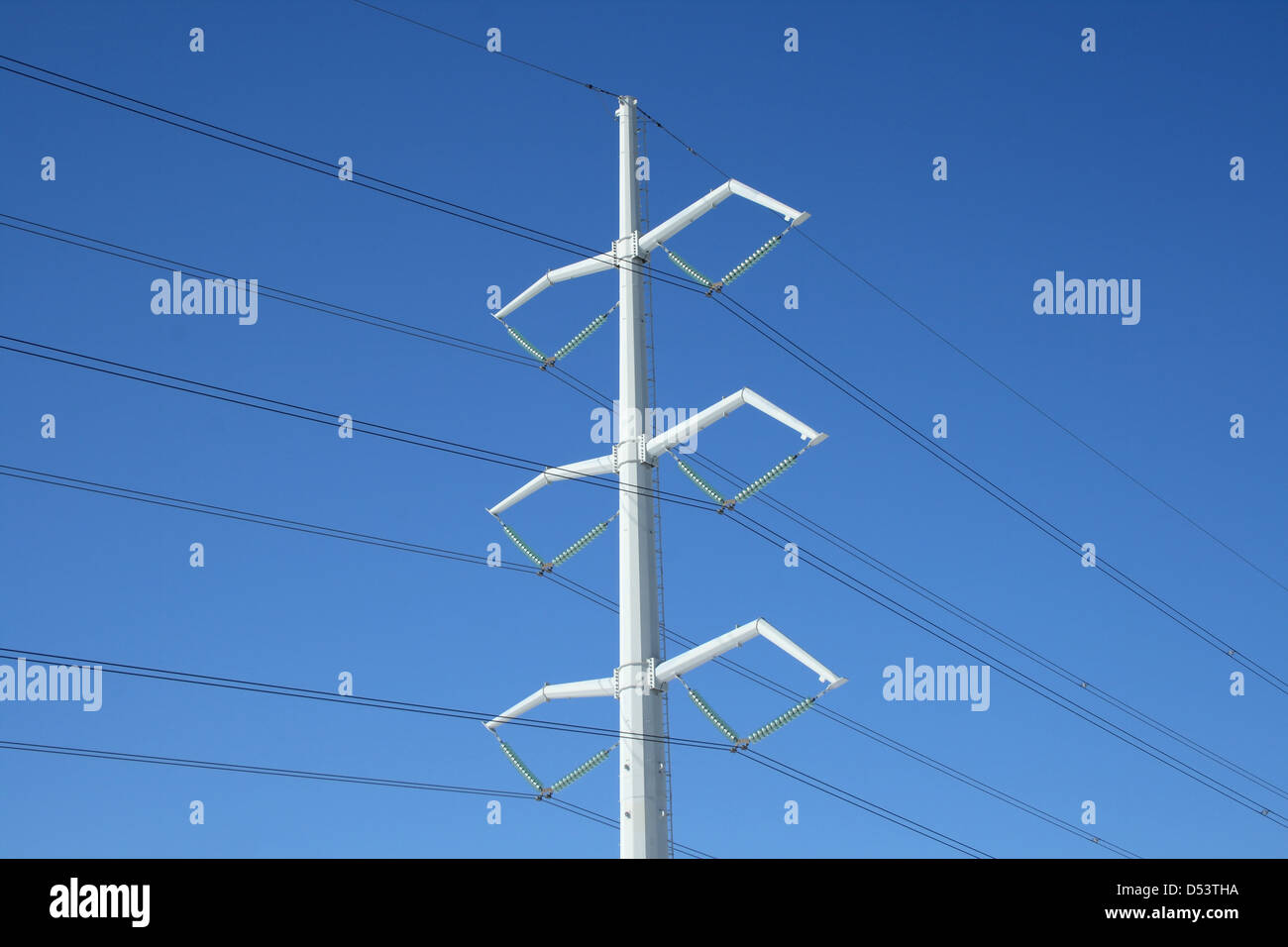 White high voltage electricity pylon and power lines against the deep ...