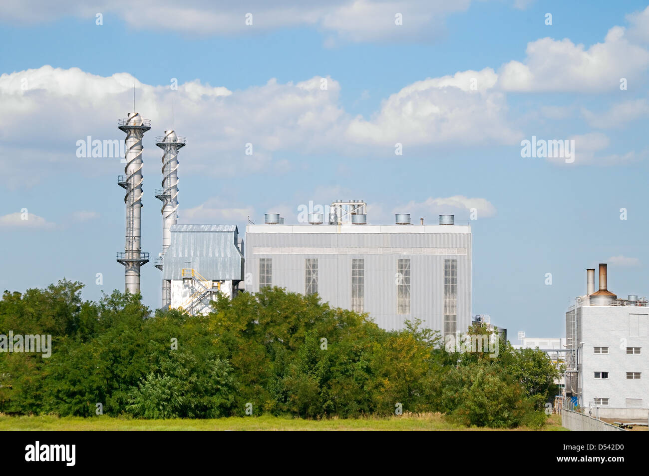 Factory pipes and building on a background of the blue sky with clouds ...