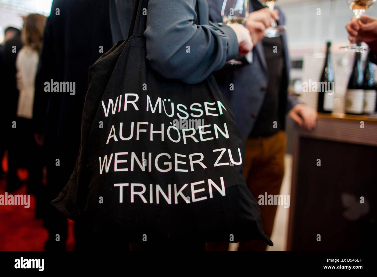 The slogan 'Wir muessen aufhoeren weniger zu trinken' ('We have to stop drink less') is written on the bag of a visitor at the wine fair ProWein in Dusseldorf, Germany, 24 March 2013. The fair takes place from 24 until 26 March 2013. Photo: ROLF VENNENBERND Stock Photo