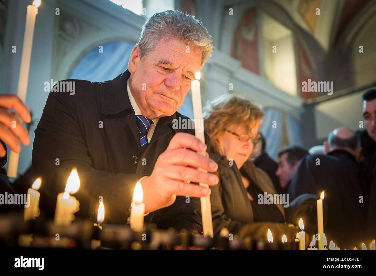 German President Joachim Gauck lights a candle in the chapel of the Tuscan village Sant'Anna di Stazzema, Italy, 24 March 2013. In 1944, Sant'Anna di Stazzema was the site of a Nazi atrocity during World War II. In the course of an operation against the Italian resistance movement about 560 local villagers and refugees were murdered and their bodies burnt in a scorched earth policy action by the German occupation forces of the Waffen-SS. Photo: JESCO DENZEL Stock Photo