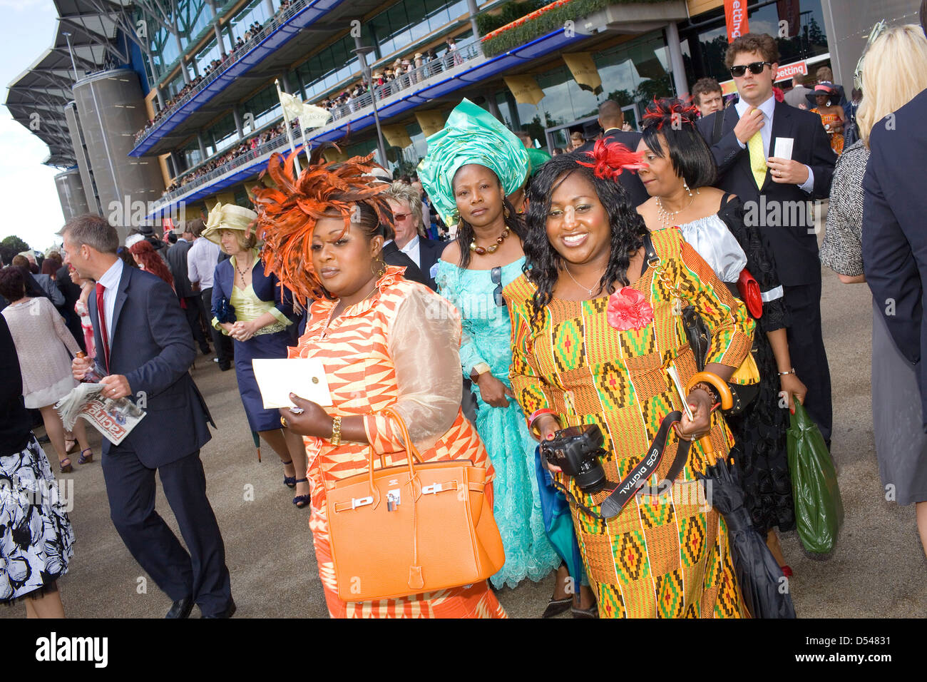 Three black women in brightly coloured dresses at Royal Ascot racecourse. Stock Photo