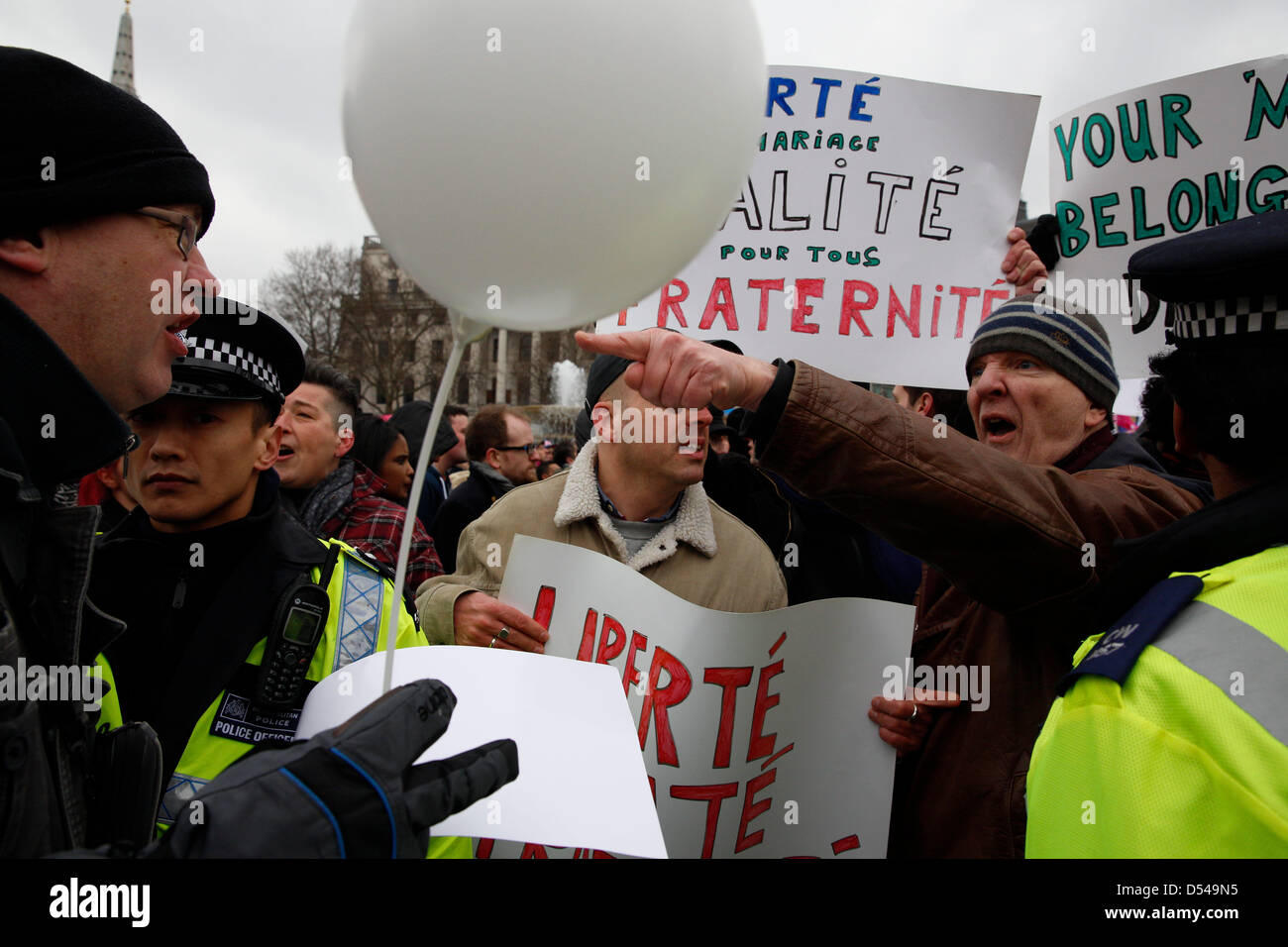 London, UK. 24th March, 2013.  Two protesters disagreeing over gay marriage while police were holding their positions.  French protesters alongside religious groups are organising an Anti-Gay rally in Trafalgar Square.  Anglican Mainstream are urging Christians to turn up to protest Stock Photo