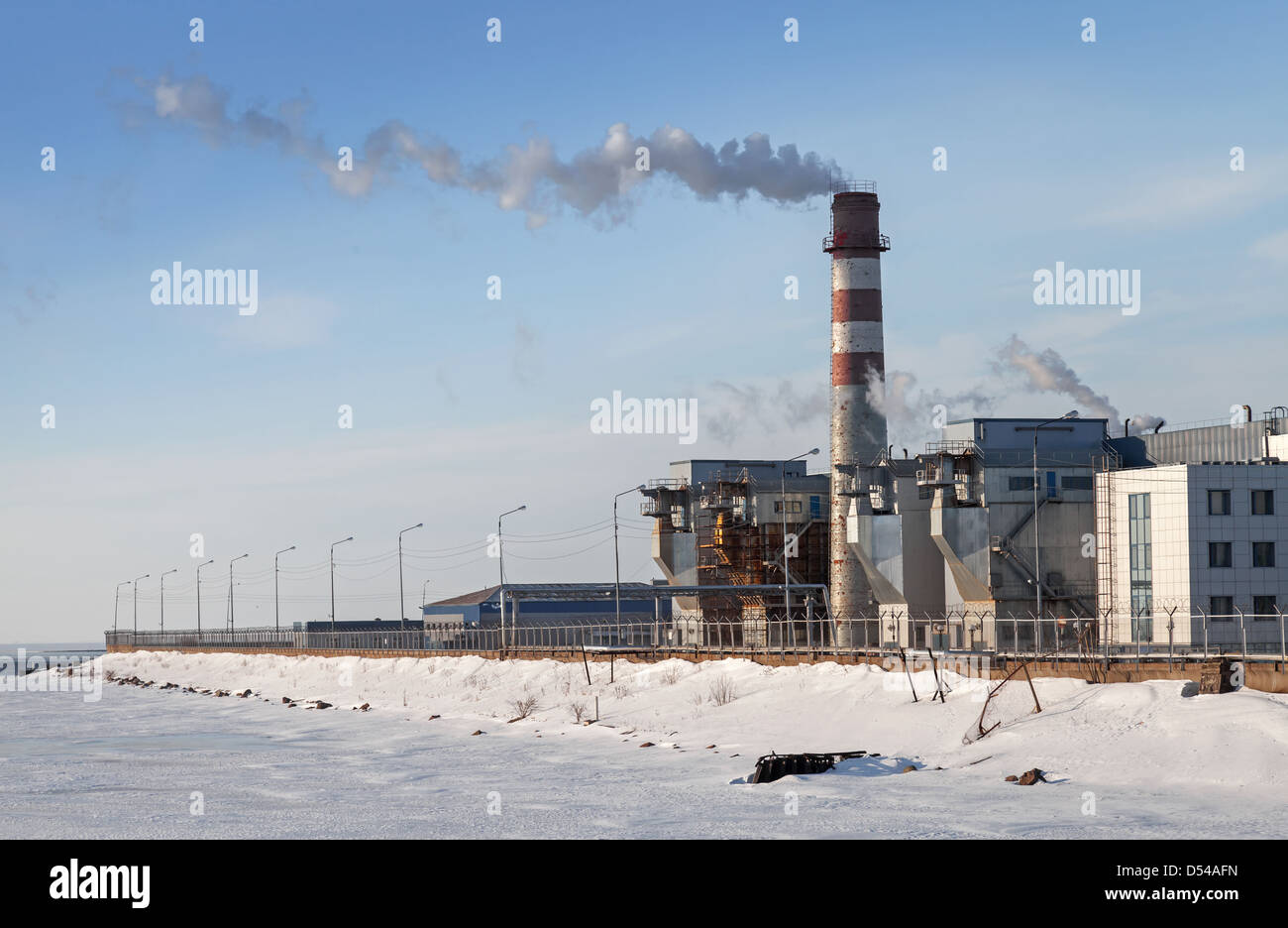 Industrial landscape. Plant tube with smoke on wind above blue sky Stock Photo