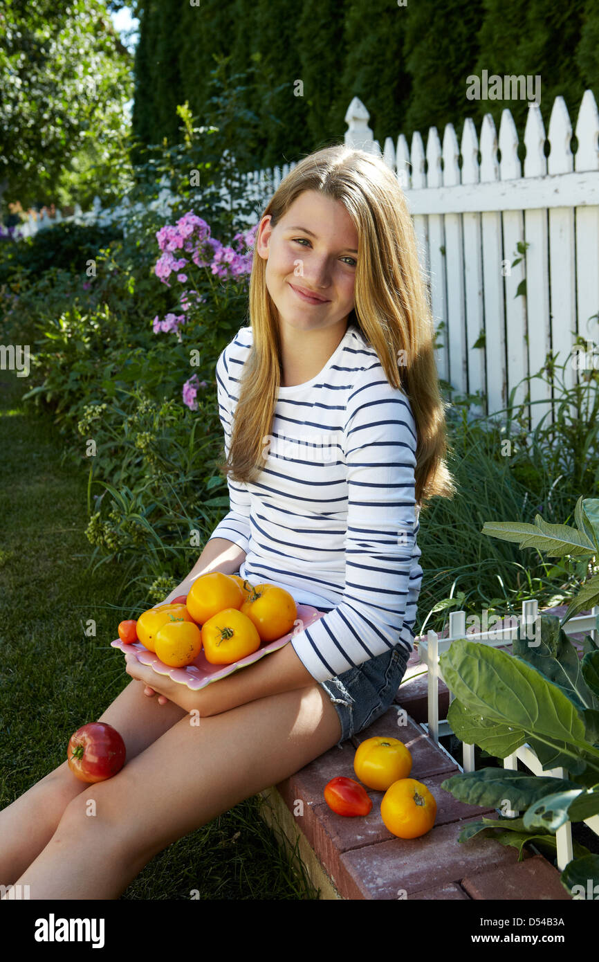 Girl holding home grown tomatoes in urban garden Stock Photo - Alamy