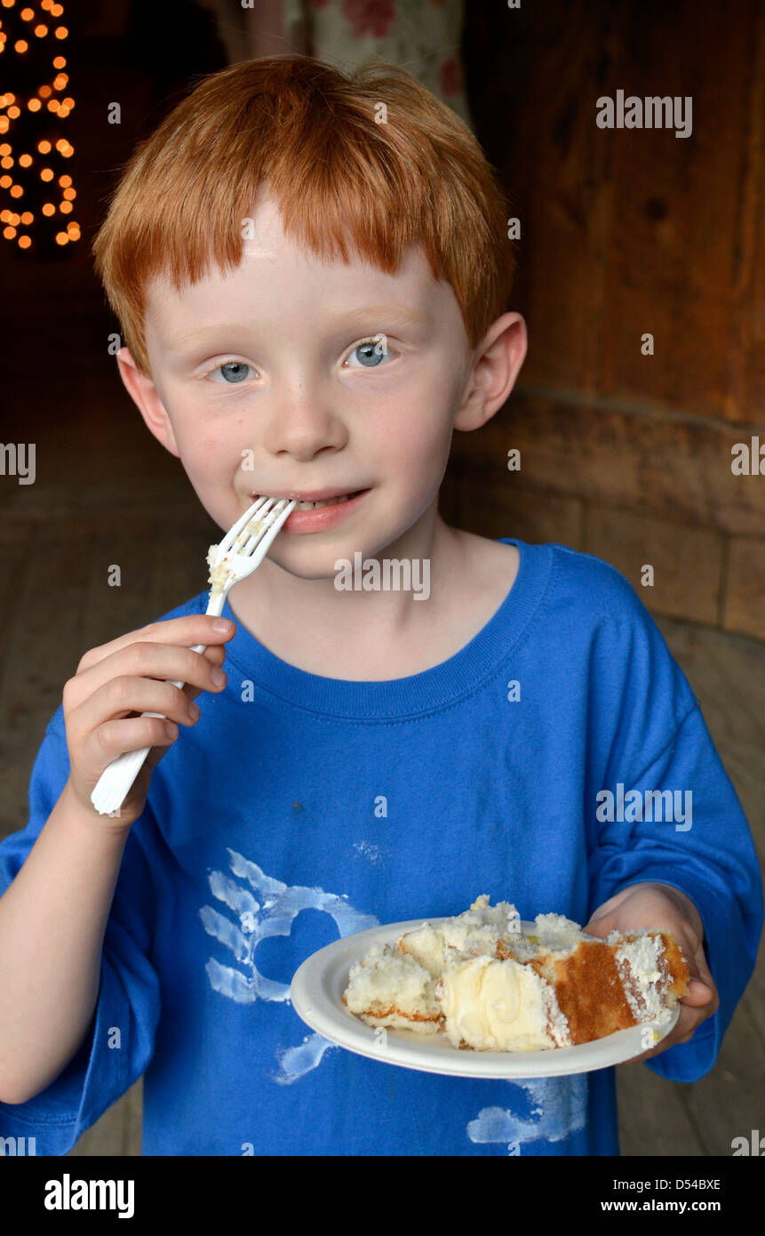 Young boy eating cake Stock Photo Alamy