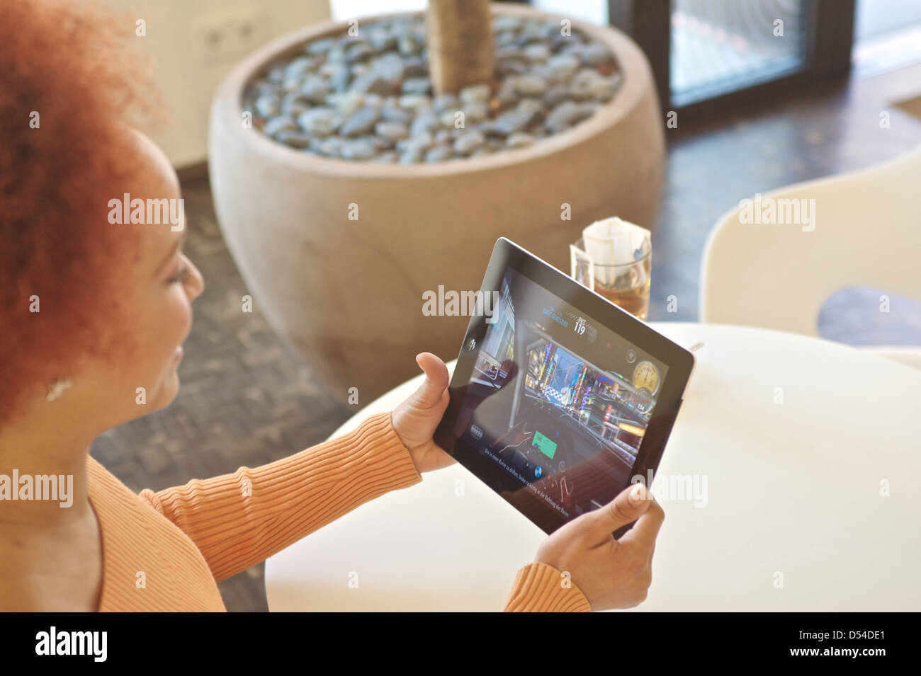 Hamburg, Germany, with its iPad 2 woman sitting in a cafe and play a game Stock Photo