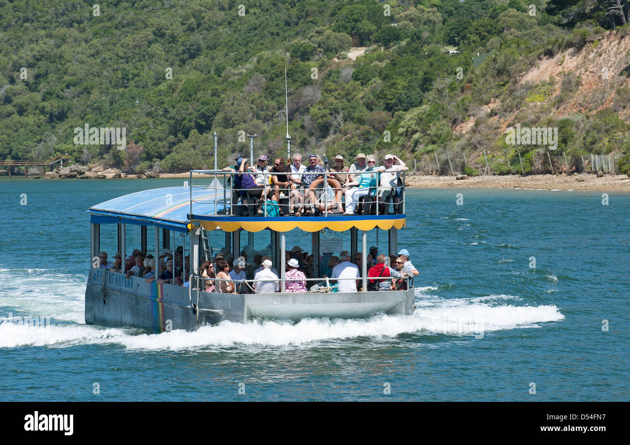 Tour boat with tourists. Knysna estuary with backdrop of Featherbed Nature Reserve. Garden Route South Africa Knysna lagoon wate Stock Photo