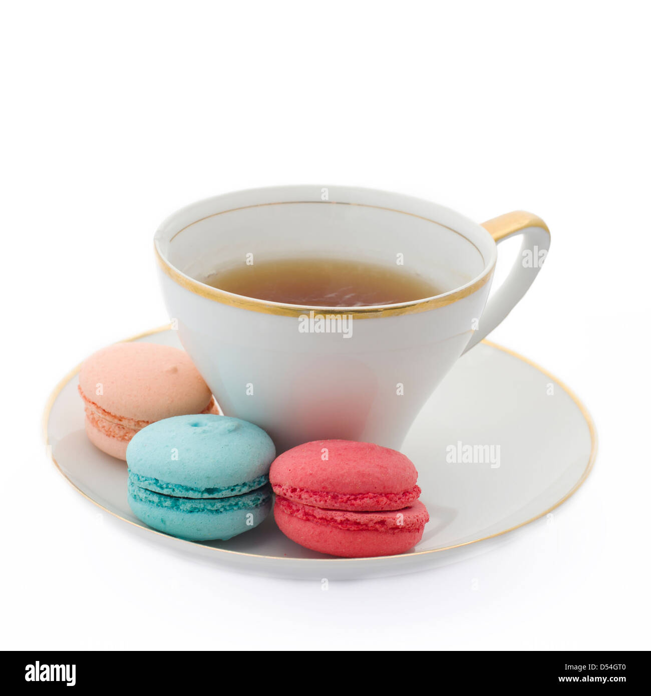 Cup of tea with three Macaron cookies in pink, blue and peach colors. Stock Photo