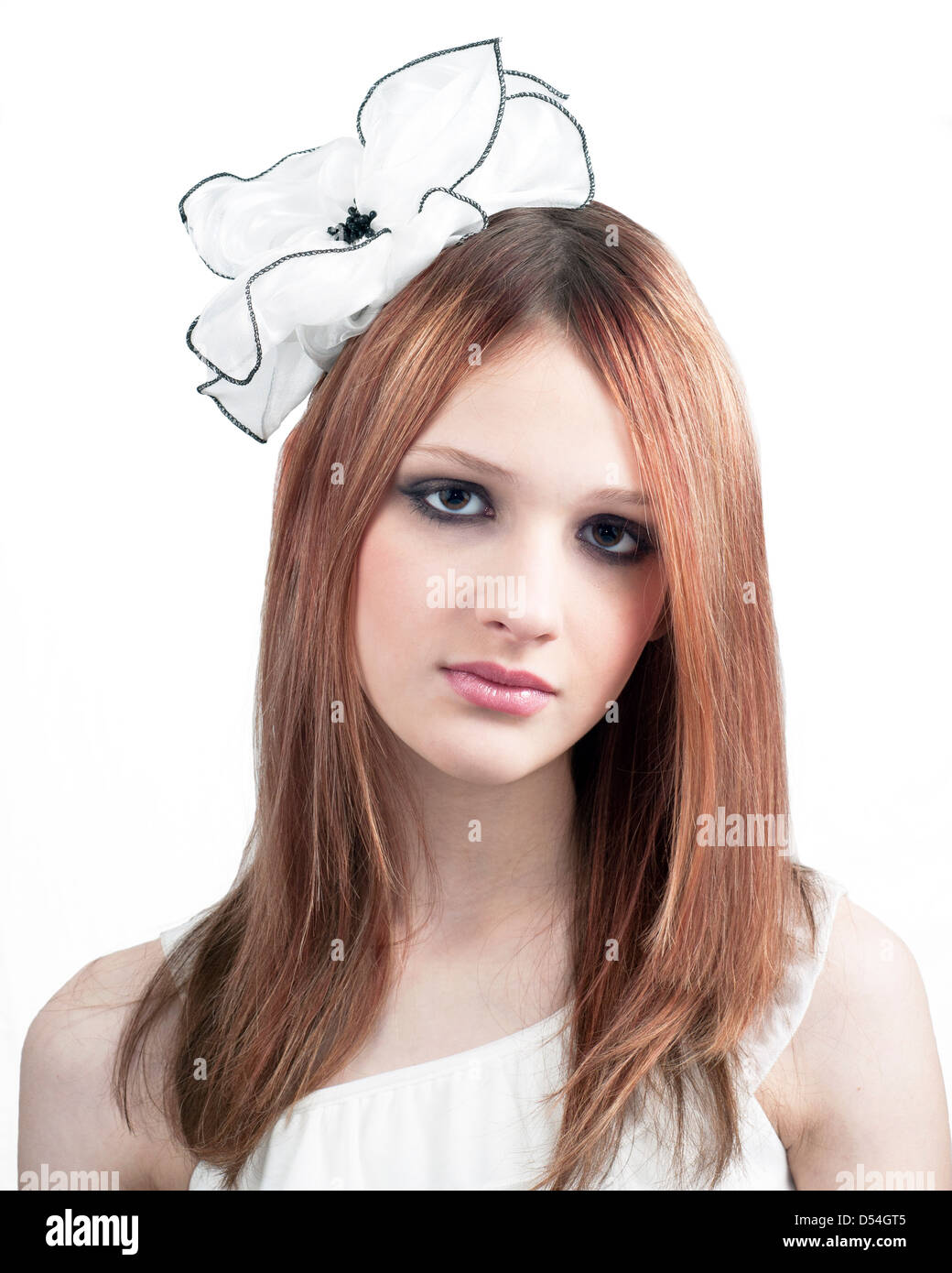 Portrait of pre-teen girl with white bow in hair against white background. Stock Photo