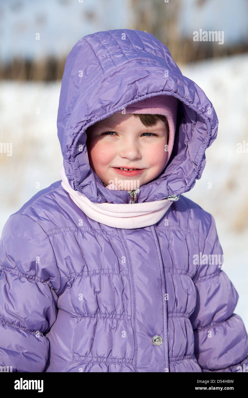Small Caucasian girl in winter clothes standing outdoor Stock Photo