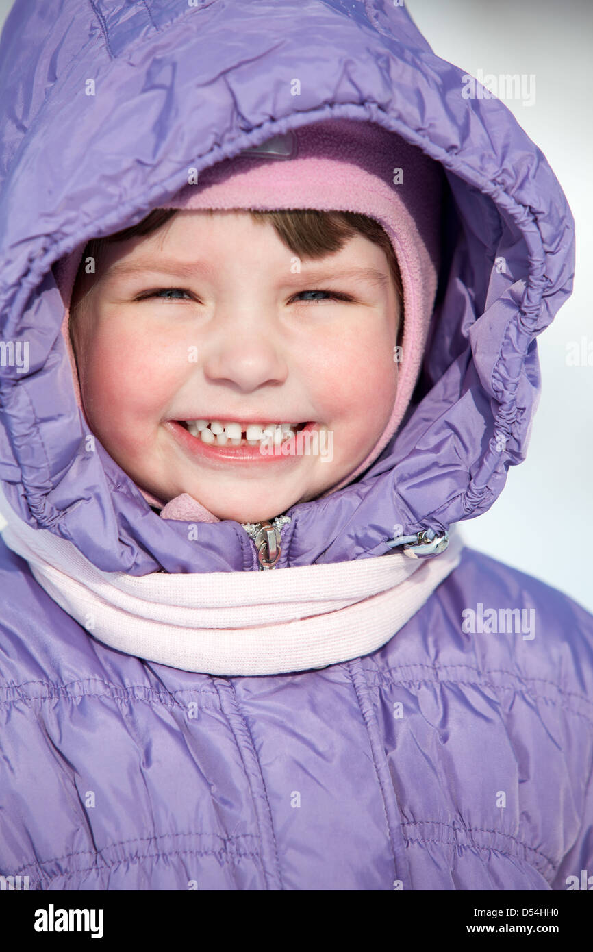 Close-up portrait of small Caucasian girl in winter clothes with hood on head Stock Photo