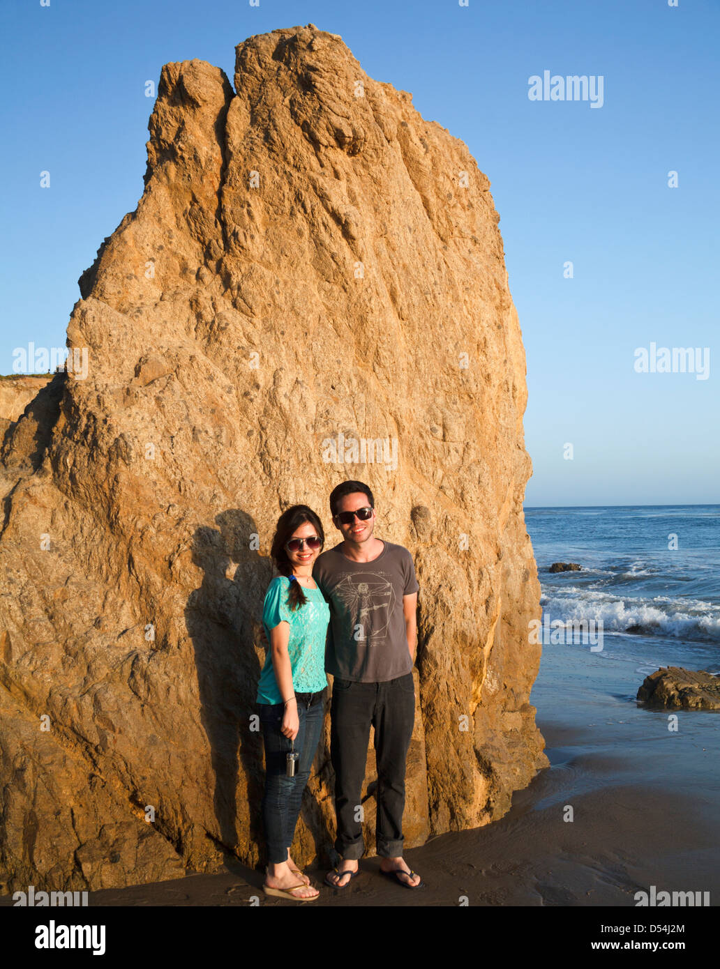 Couple bathed in golden light at  El Matador State Beach in Southern California Stock Photo