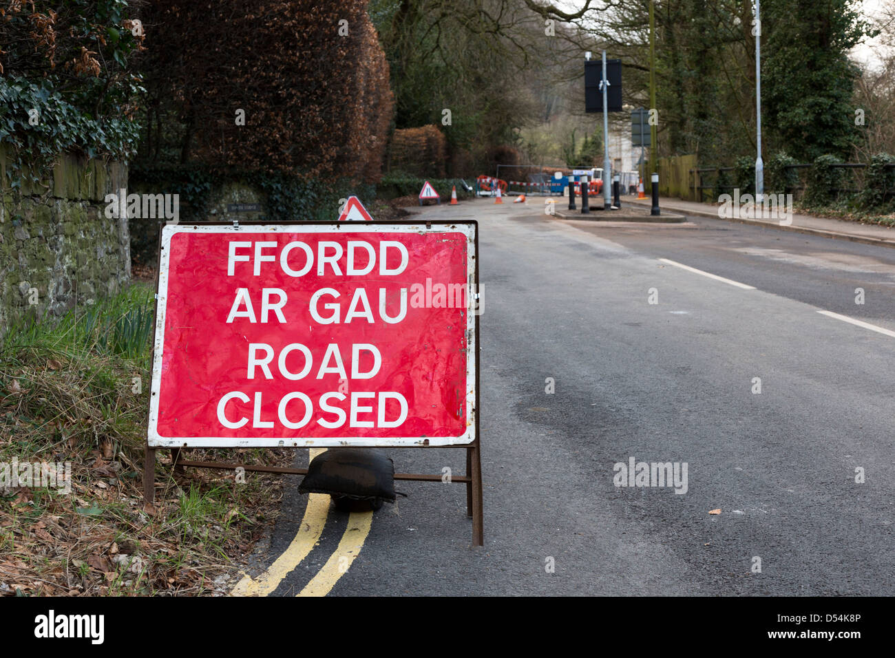 Road closed sign in English and Welsh while roadworks for water supply repaired, Llanfoist, Wales, UK Stock Photo