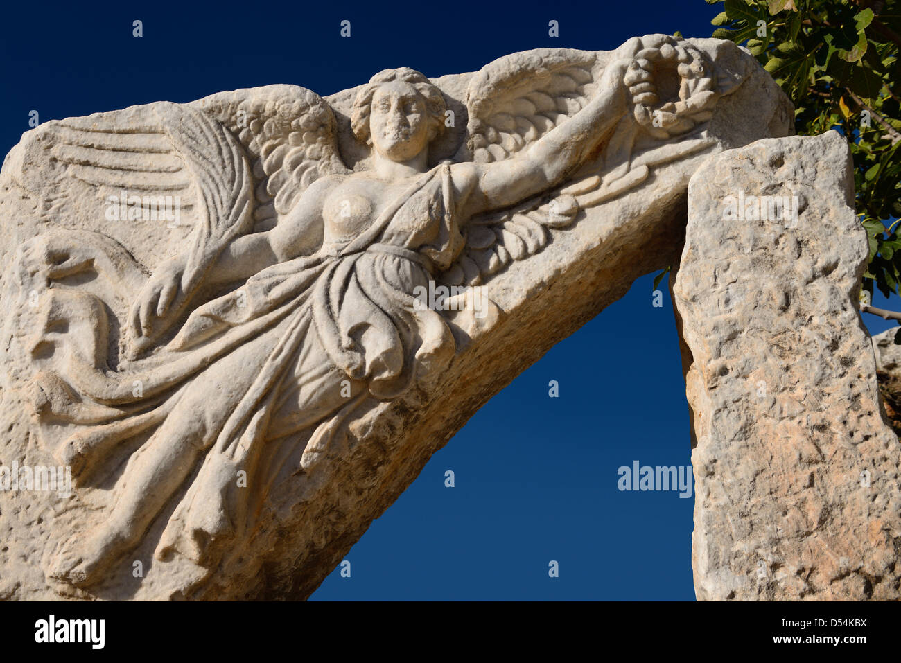 Stone sculpture relief from the door of Heracles of Winged Nike the Goddess of victory at ancient Ephesus ruins Turkey with blue sky Stock Photo