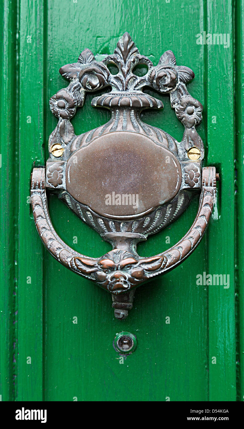 Old brass door knocker on green painted door, Rhaeadr, Wales, UK Stock Photo