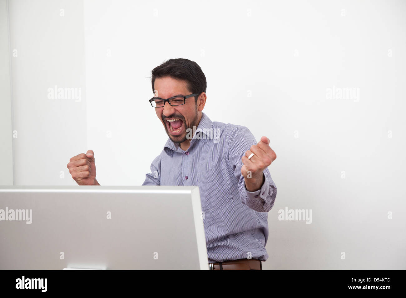 Freiburg, Germany, businessman cheering in front of a computer Stock Photo