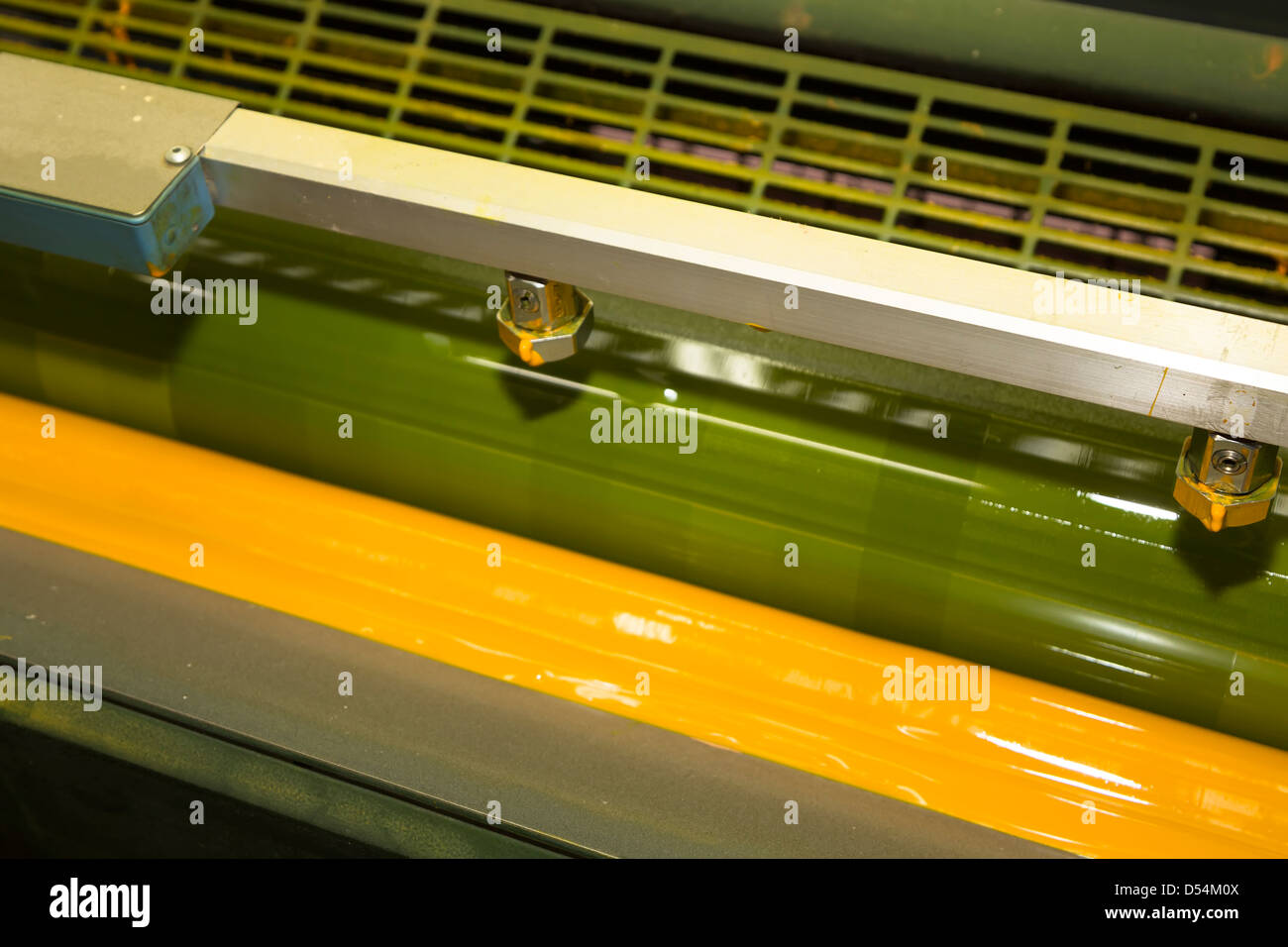 Offset litho printing press showing yellow ink applied from roller, Aberystwyth, Wales, UK Stock Photo