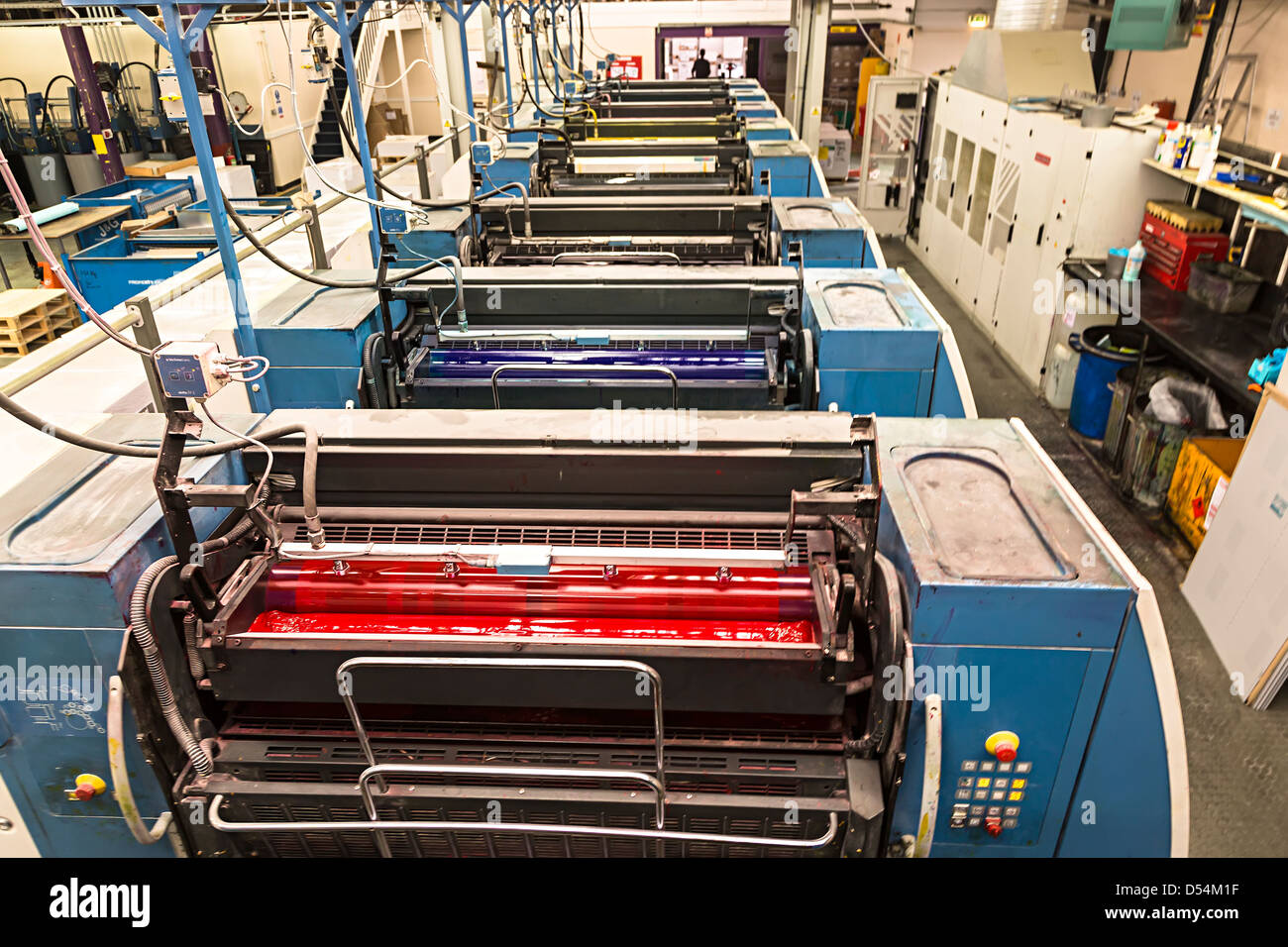 Offset litho printing press showing magenta, cyan, yellow and black inks applied from rollers, Aberystwyth, Wales, UK Stock Photo