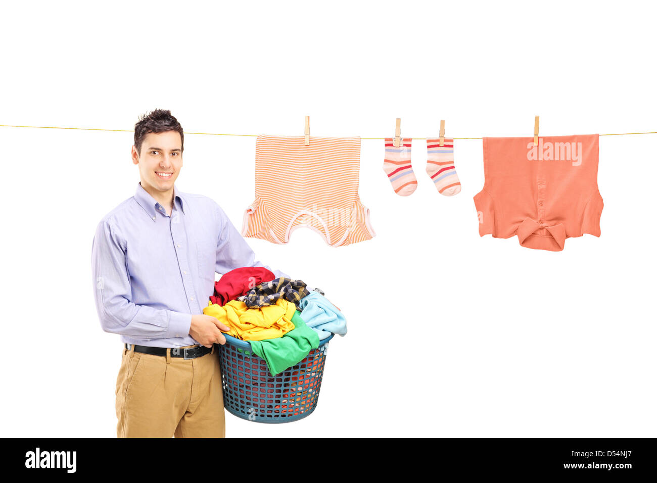 Smiling guy holding a laundry bin and a laundry line with clothes isolated on white background Stock Photo