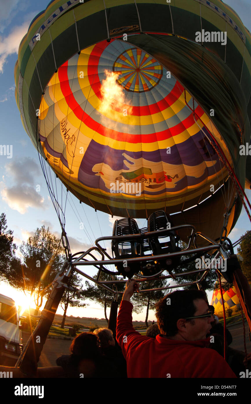 A crew member heats the air inside a hot air balloon envelope before a