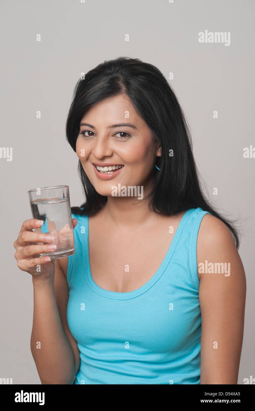 Woman holding a glass of water and smiling Stock Photo - Alamy