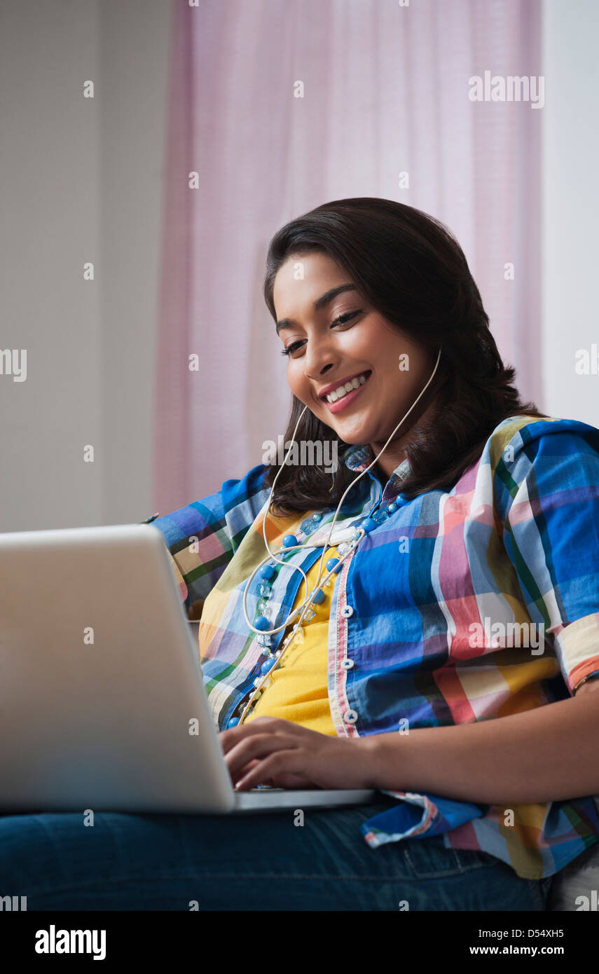 Teenage girl using a laptop and smiling Stock Photo - Alamy