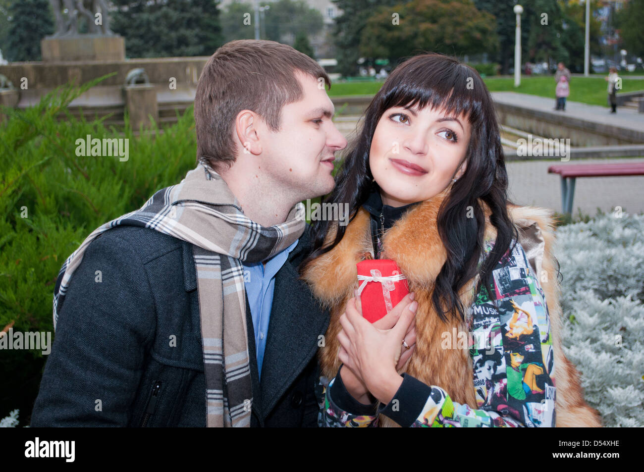 the happy couple siting on the bench in the autumn park Stock Photo - Alamy