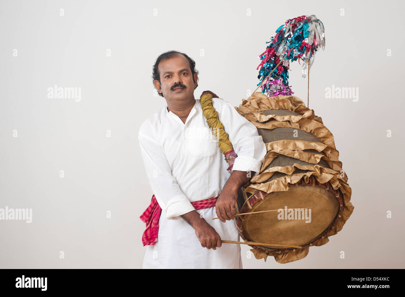 Bengali man playing dhol (A large drum used to play during festival and