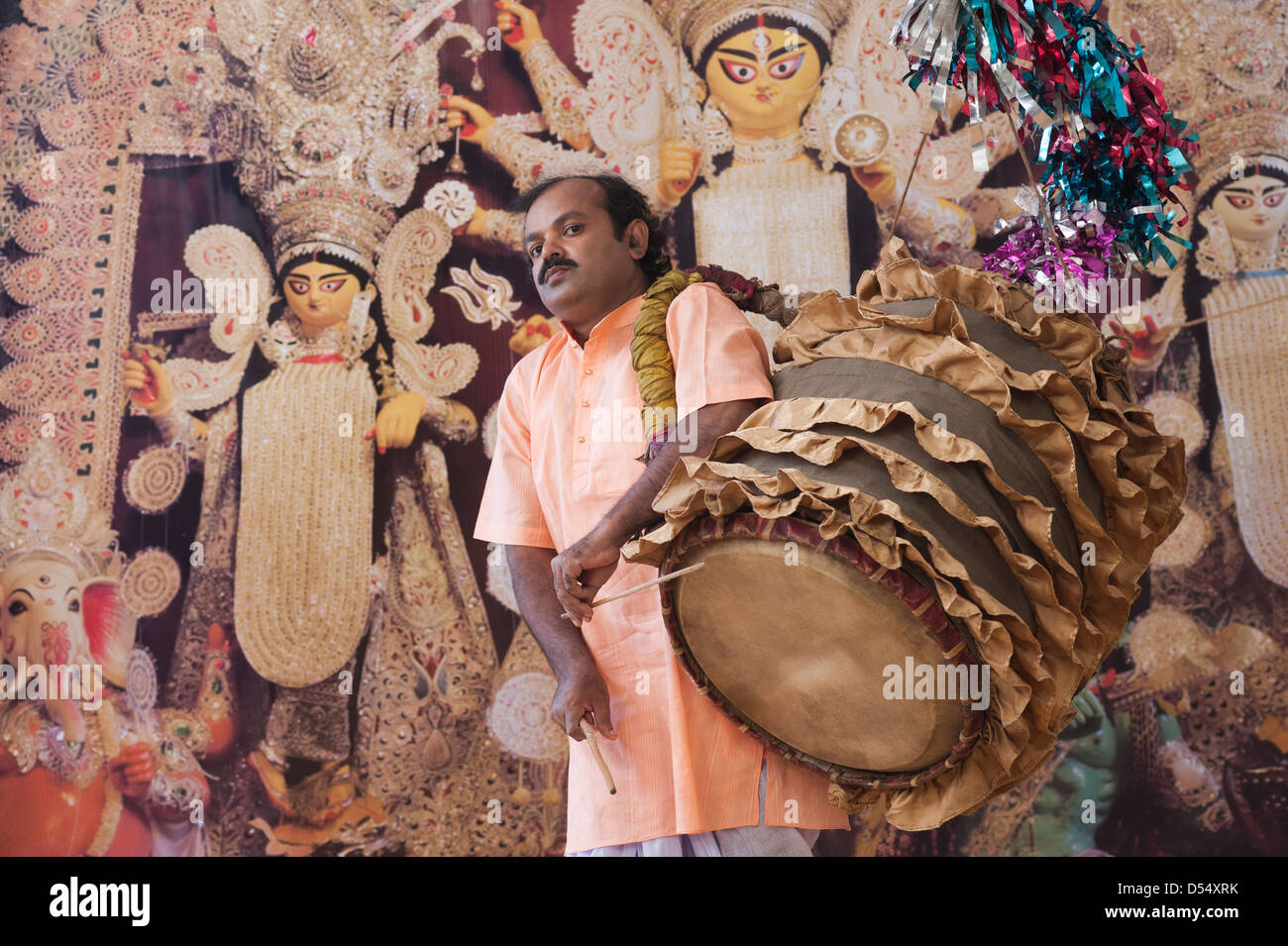 Bengali man playing dhol (A large drum used to play during festival and