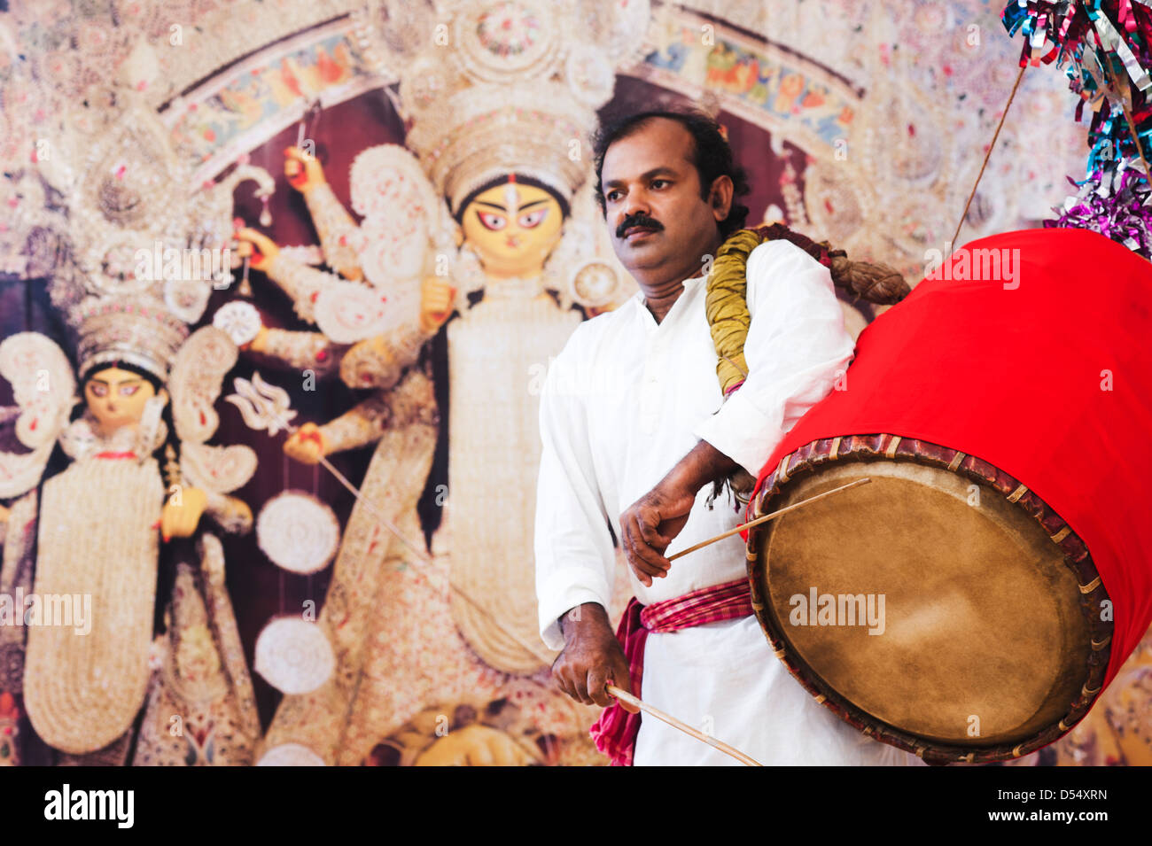 Bengali man playing dhol (A large drum used to play during festival and celebration in India