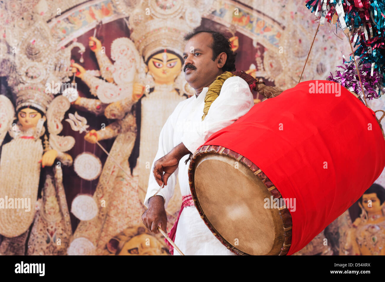 Bengali man playing dhol (A large drum used to play during festival and