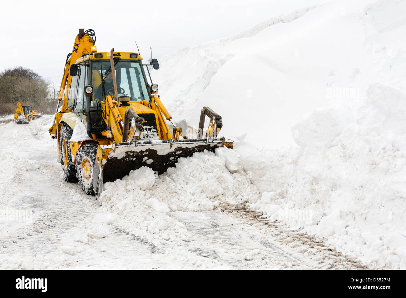 Carrickfergus, Northern Ireland, UK. 25th March 2013.  JCBs clear roads hit by snow drifts over three metres deep.  Credit:  Stephen Barnes / Alamy Live News Stock Photo