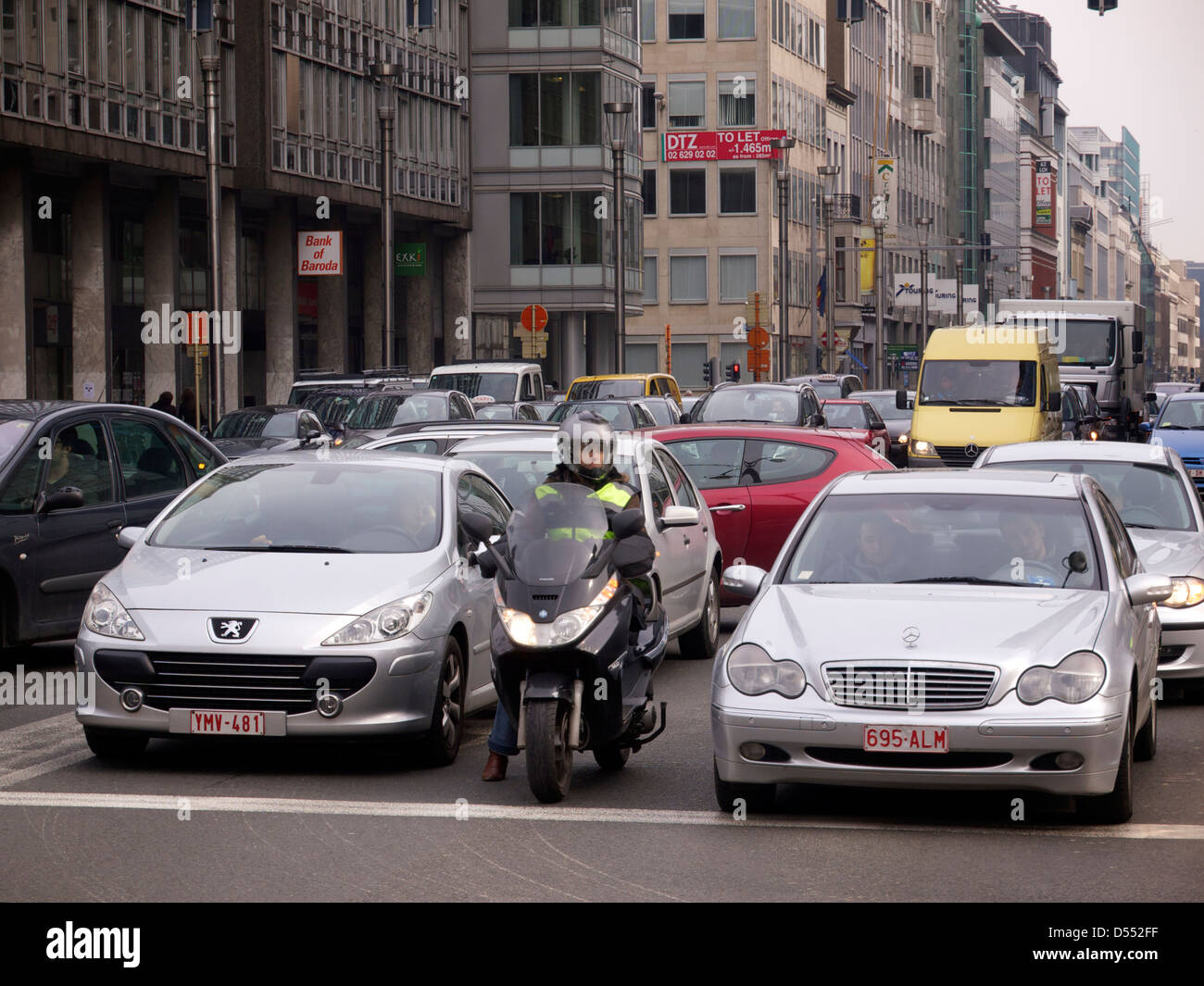 Brussels is one of the most congested cities in Europe and this woman tries to beat the traffic using a motorcycle. Stock Photo