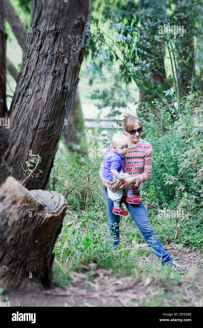 Mother and son walking in forest Stock Photo