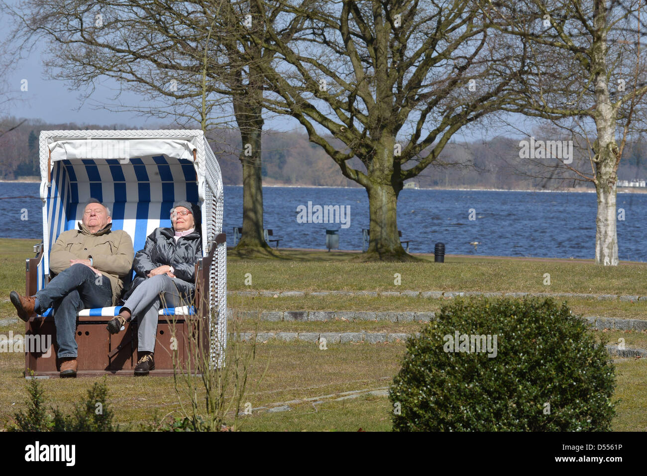 A couple enjoys the warmth of the sun, while sitting in a beach chair at the Bad Zwischenahner Meer (lake) in Bad Zwischenahn, Germany, 25 March 2013. Photo: Carmes Jaspersen Stock Photo