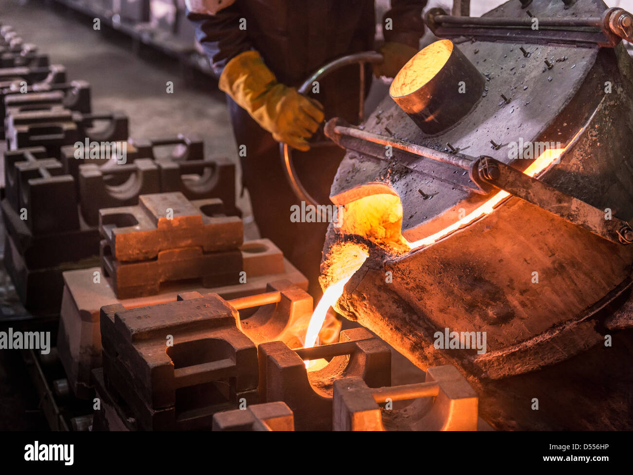 Worker pouring molten metal in foundry Stock Photo