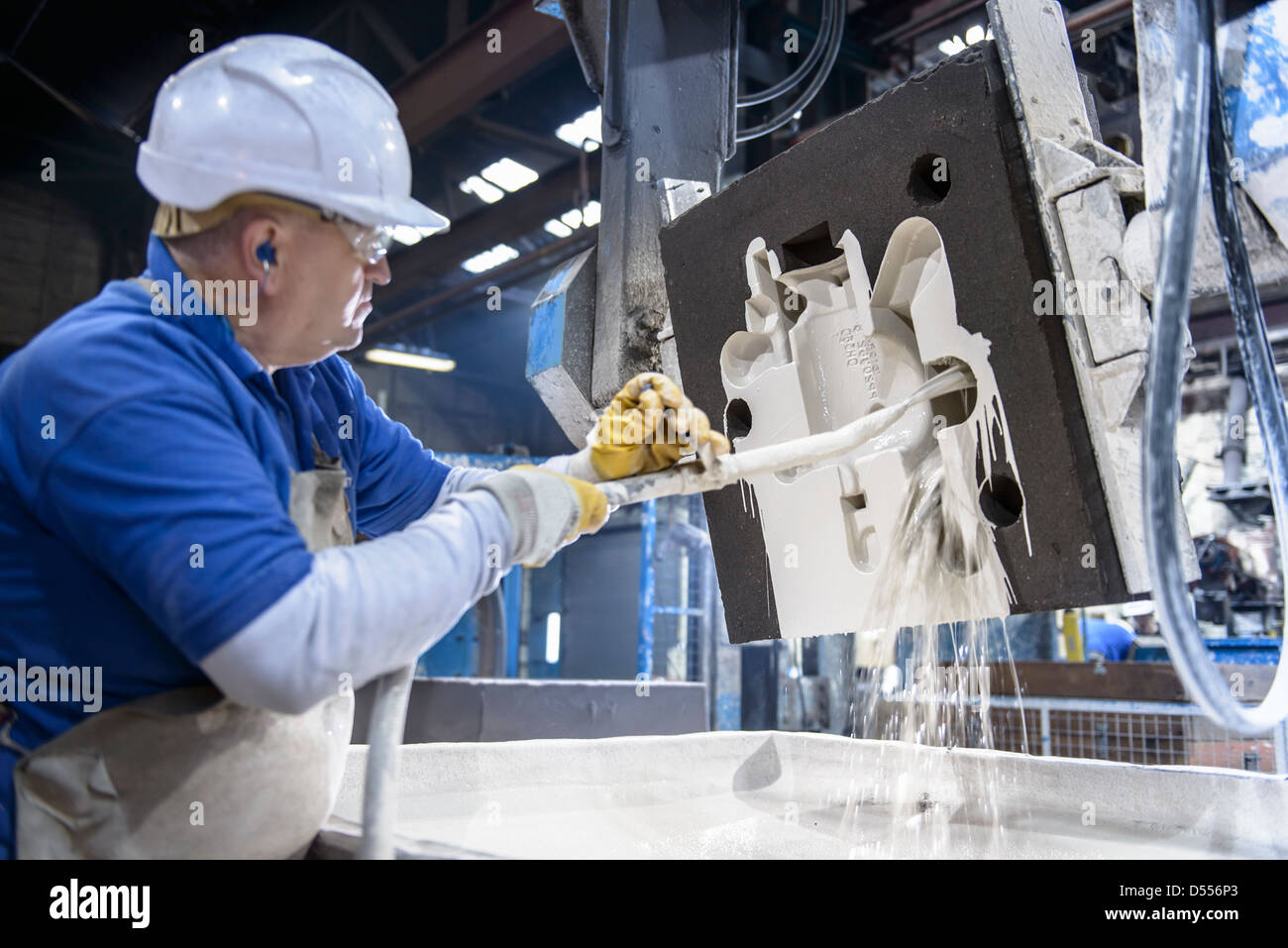 Worker coating mould in metal foundry Stock Photo