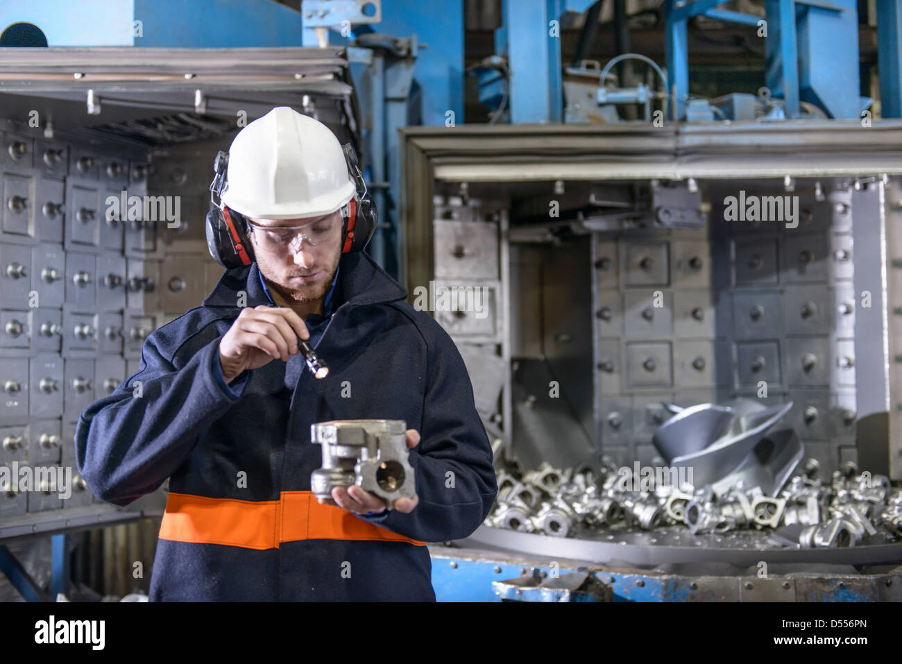 Worker inspecting metal in foundry Stock Photo
