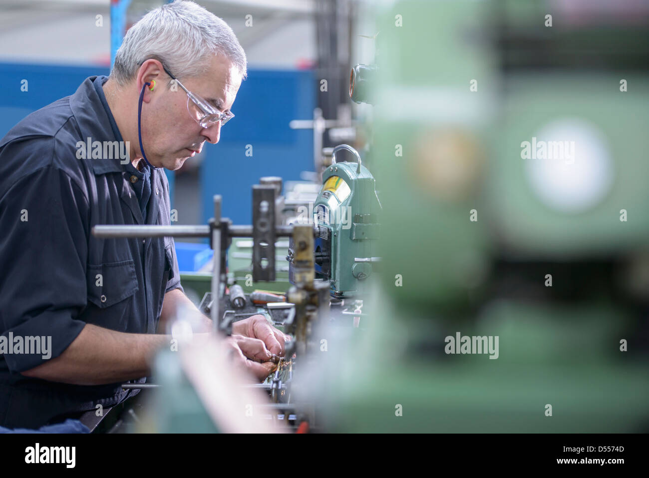 Worker polishing steel parts in factory Stock Photo Alamy