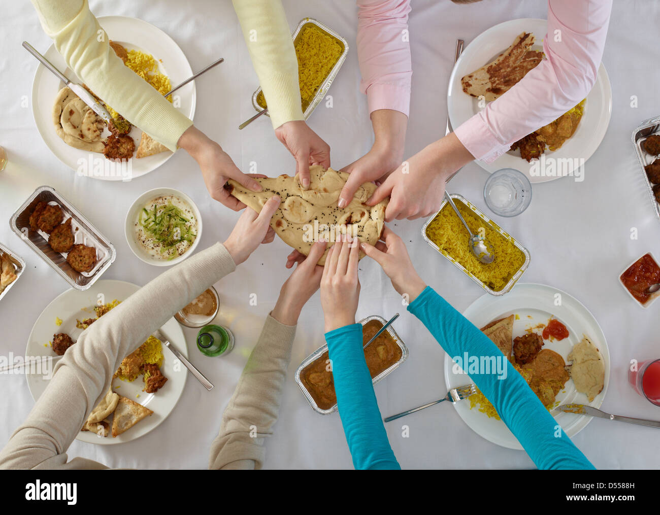 Overhead view of people sharing at table Stock Photo