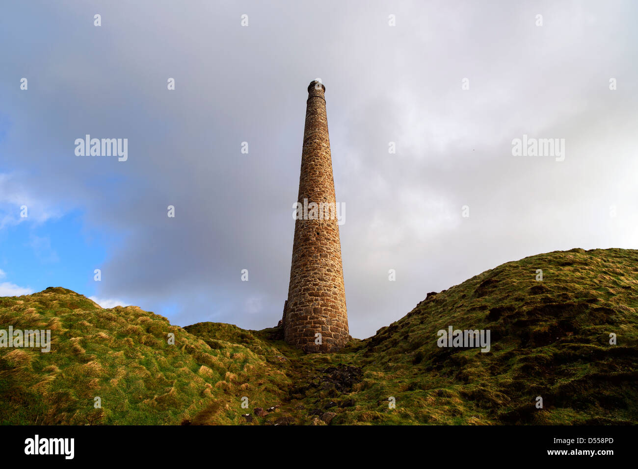 A lone chimney from abondoned tin mines reaches for the sky on Cornwall's rugged West coast, near Land's End.  Stock Photo
