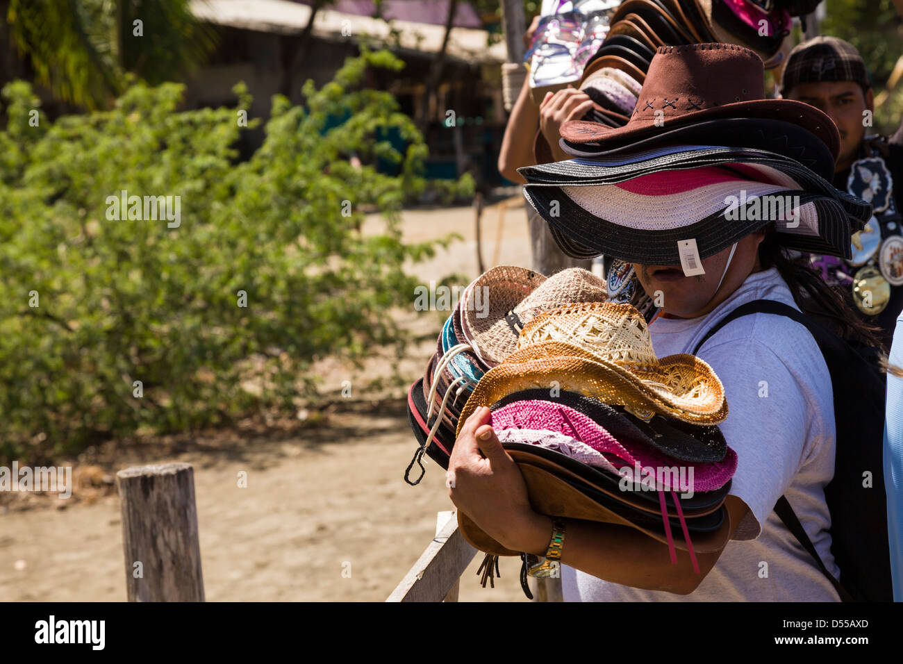 Vendor carrying a full load of hats at Coco Beach, Playas del Coco, Guanacaste, Costa Rica. Stock Photo