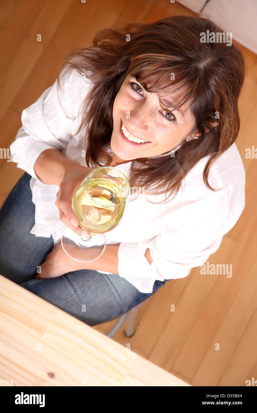 A beautiful mature woman with a glass of white wine Stock Photo - Alamy
