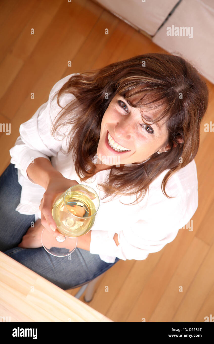 A beautiful mature woman with a glass of white wine Stock Photo - Alamy